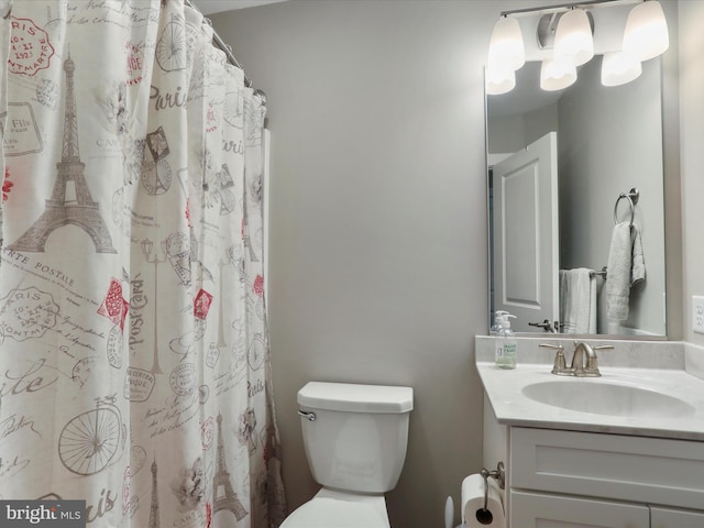 bathroom featuring curtained shower, vanity, and toilet