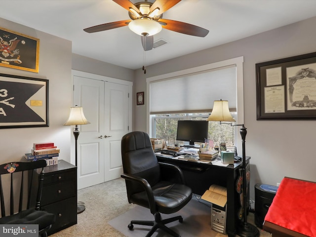 carpeted home office featuring ceiling fan