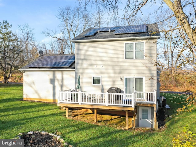 rear view of property featuring solar panels, a yard, central AC, and a wooden deck