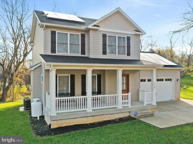 view of front of house featuring solar panels, a front yard, covered porch, central AC unit, and a garage