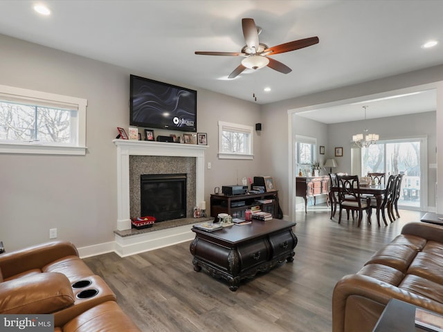 living room featuring ceiling fan with notable chandelier and dark hardwood / wood-style floors