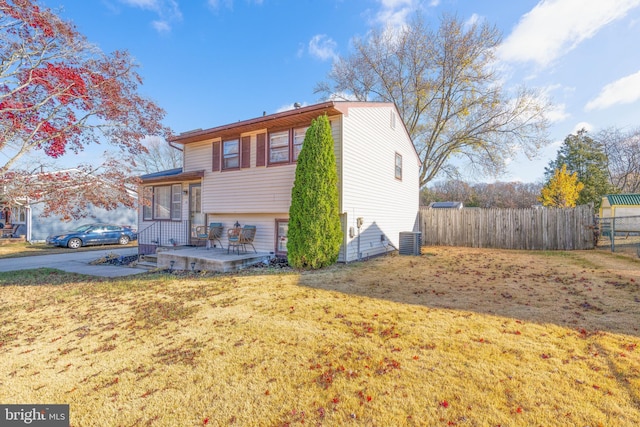 view of front of home with a patio area, a front lawn, and central AC unit