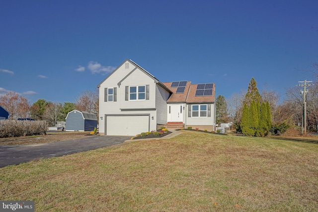 front of property with a front lawn, a garage, and solar panels