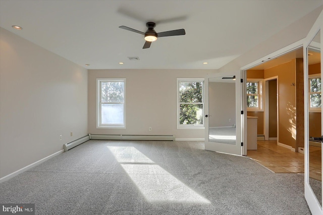 carpeted empty room with ceiling fan, plenty of natural light, and a baseboard radiator