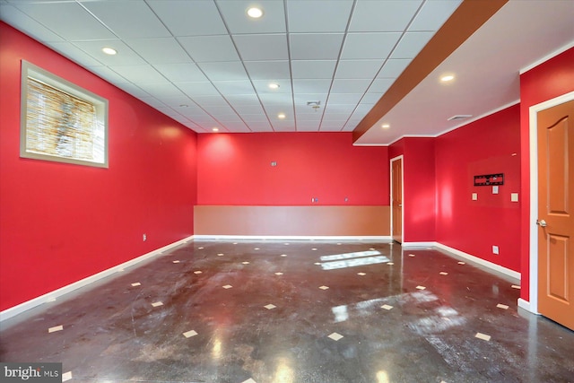 unfurnished room with a drop ceiling and concrete floors