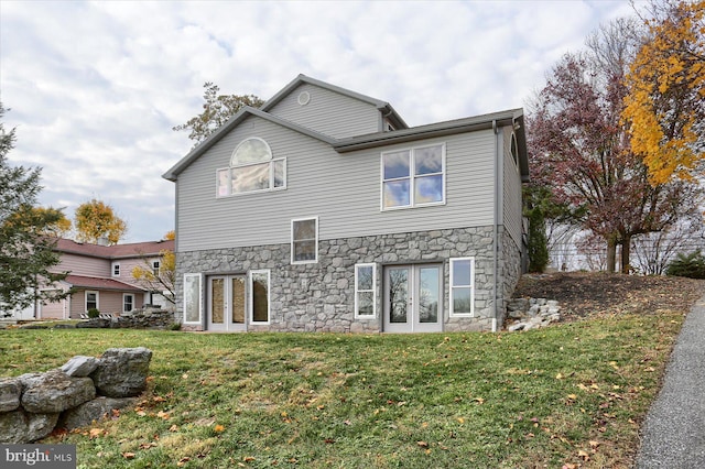 rear view of property featuring a yard and french doors