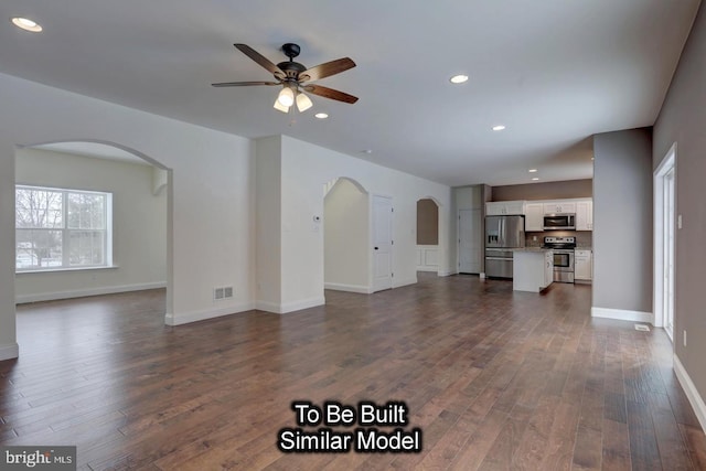 unfurnished living room with ceiling fan and dark wood-type flooring