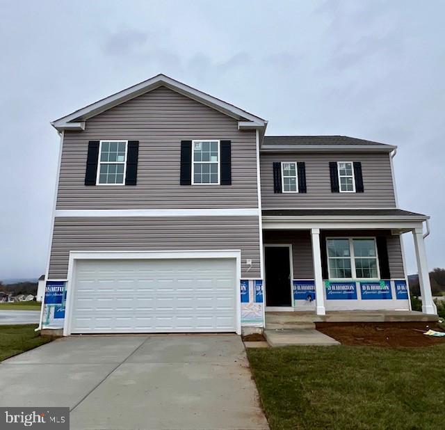 view of front of home featuring a porch, a garage, and a front lawn