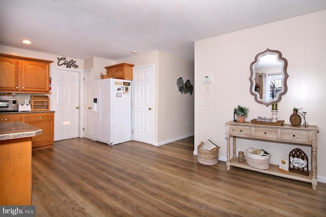 kitchen featuring decorative backsplash, dark hardwood / wood-style flooring, and white refrigerator with ice dispenser