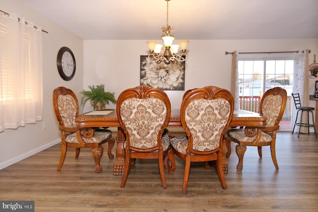 dining area with a notable chandelier and hardwood / wood-style flooring