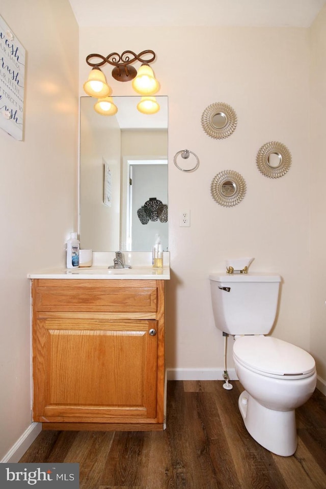 bathroom with hardwood / wood-style flooring, vanity, and toilet