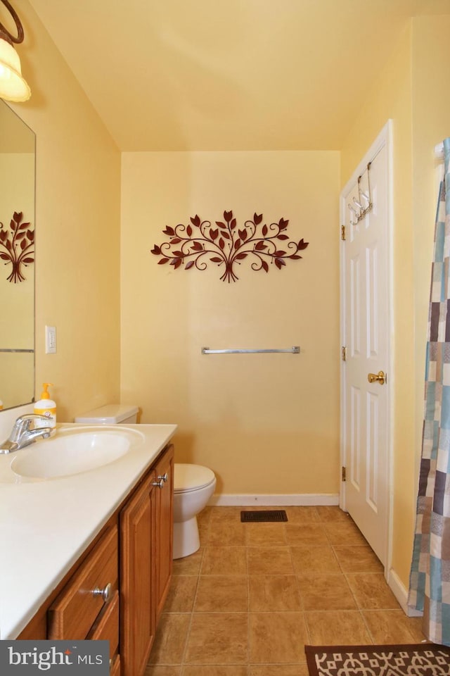 bathroom featuring tile patterned flooring, vanity, and toilet