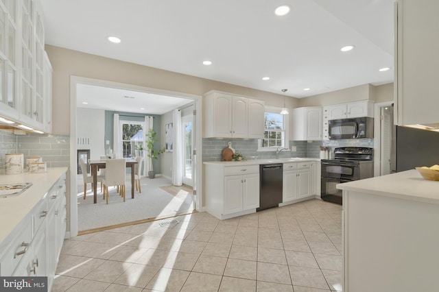 kitchen with backsplash, black appliances, white cabinets, sink, and light tile patterned floors