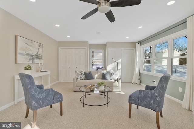 living area featuring ceiling fan and light colored carpet