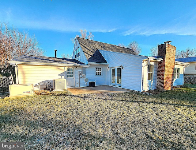 rear view of property with a lawn, a patio area, french doors, and central AC