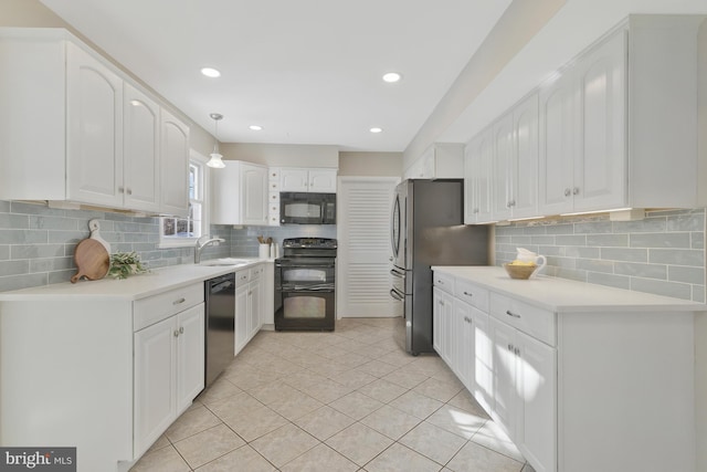 kitchen featuring sink, white cabinets, decorative light fixtures, light tile patterned flooring, and black appliances