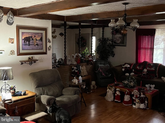 living room with beamed ceiling, wood-type flooring, and a textured ceiling