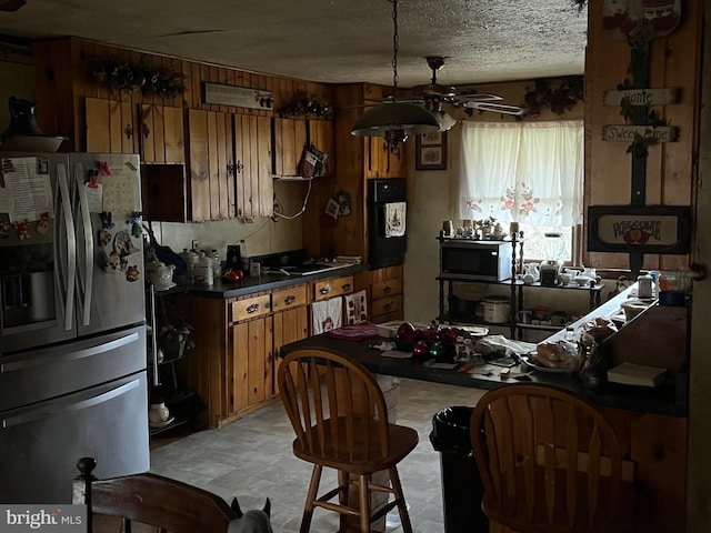 560 Frosty Hollow Rd, Fisher, WV 26818 - kitchen with appliances with stainless steel finishes, brown cabinetry, ceiling fan, and a textured ceiling