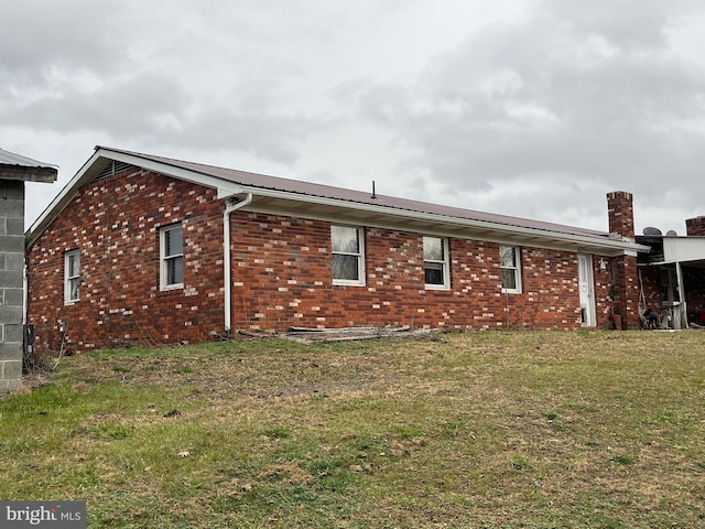 560 Frosty Hollow Rd, Fisher, WV 26818 - view of side of property featuring brick siding, a lawn, a chimney, and metal roof
