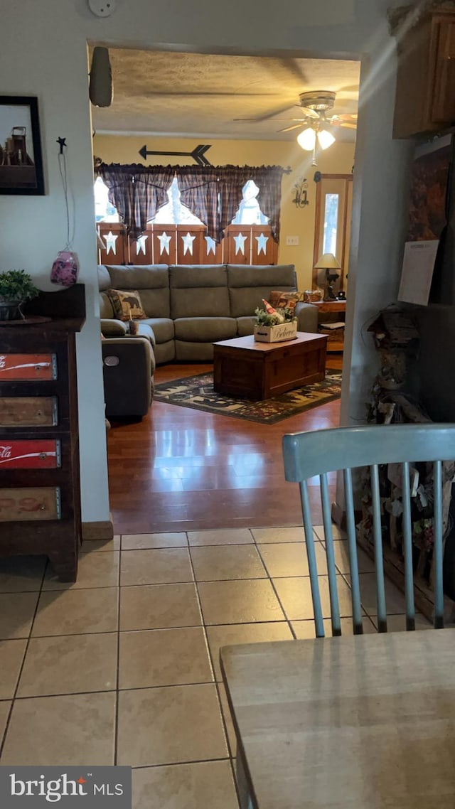 living room featuring tile patterned floors and ceiling fan