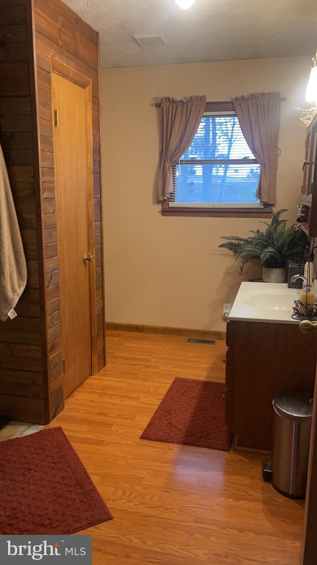 bathroom with a textured ceiling, vanity, and hardwood / wood-style flooring