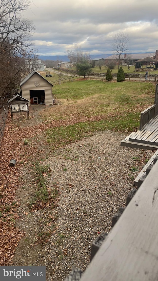 view of yard with a rural view and an outdoor structure