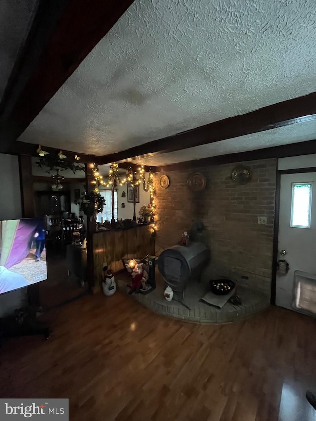 dining space featuring beamed ceiling, a textured ceiling, and hardwood / wood-style flooring