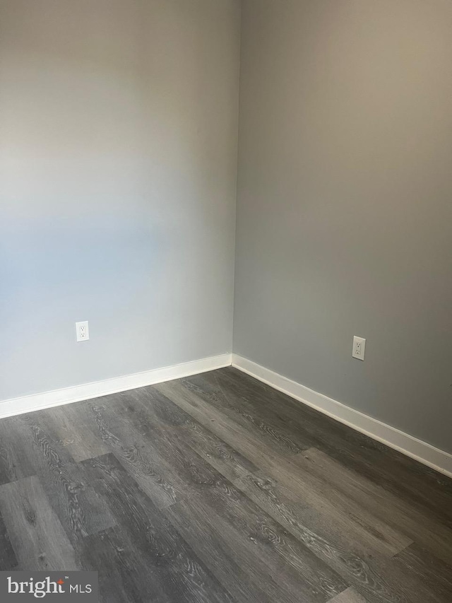 unfurnished room with dark wood-type flooring