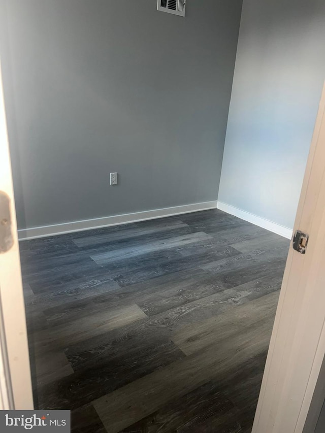 spare room with dark wood-type flooring