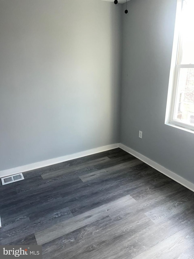 spare room with dark wood-type flooring