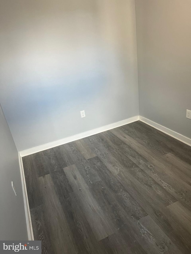 spare room featuring dark wood-type flooring