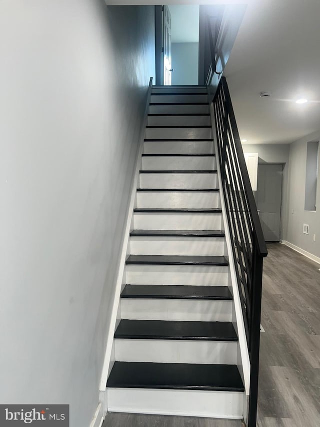 staircase with hardwood / wood-style flooring