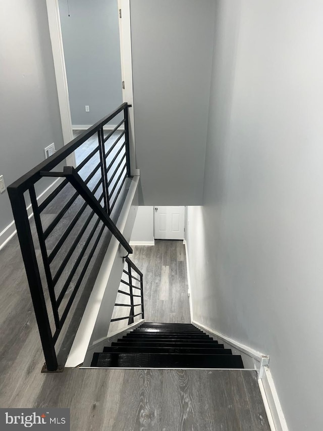 staircase with hardwood / wood-style floors