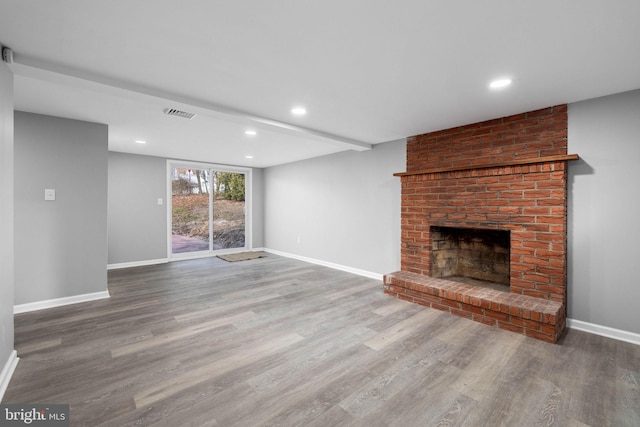 unfurnished living room with wood-type flooring and a fireplace