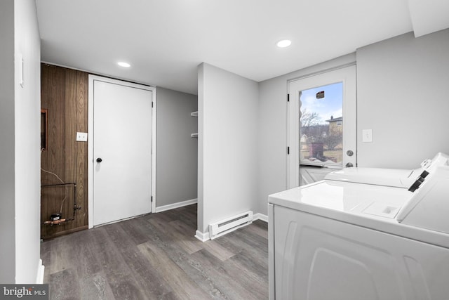 washroom with washer and dryer, wood-type flooring, and a baseboard radiator