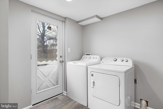 clothes washing area featuring washer and dryer and light wood-type flooring