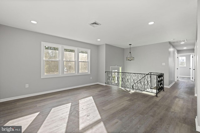 spare room with dark hardwood / wood-style flooring and a healthy amount of sunlight