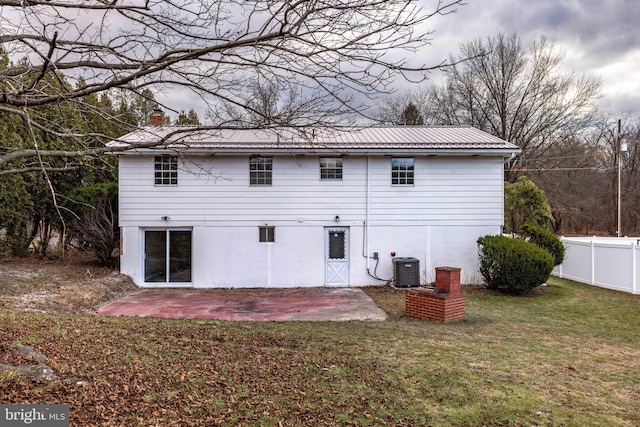 rear view of property featuring a lawn, a patio area, and central AC