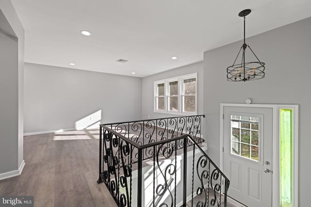 corridor with a chandelier and hardwood / wood-style flooring