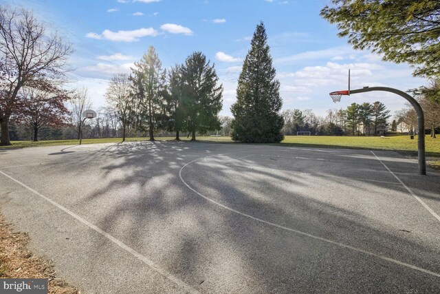 view of sport court with a lawn