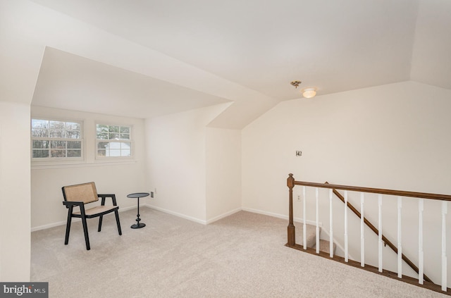 living area featuring light colored carpet and lofted ceiling