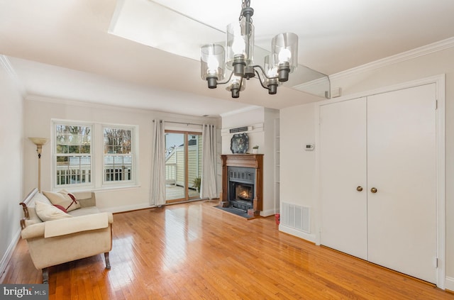 interior space featuring hardwood / wood-style flooring, crown molding, and a notable chandelier