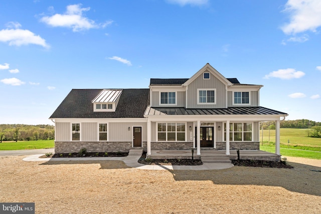 modern inspired farmhouse with a front lawn and covered porch