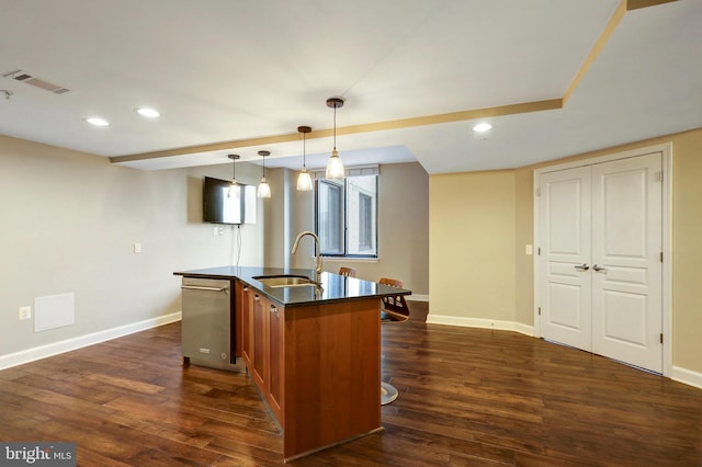 kitchen with dishwasher, sink, dark hardwood / wood-style floors, an island with sink, and pendant lighting