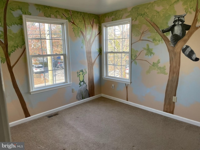 spare room featuring carpet flooring and a wealth of natural light