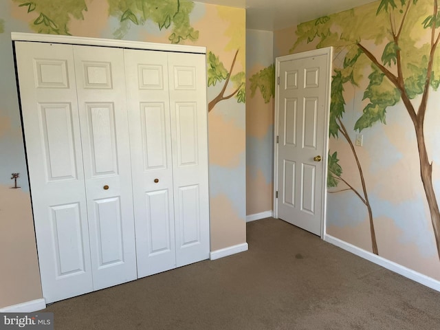 unfurnished bedroom featuring dark carpet and a closet