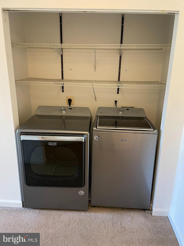 washroom with washer and clothes dryer and light colored carpet