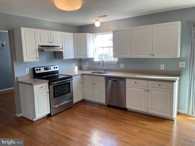 kitchen with white cabinets, appliances with stainless steel finishes, light hardwood / wood-style flooring, and sink