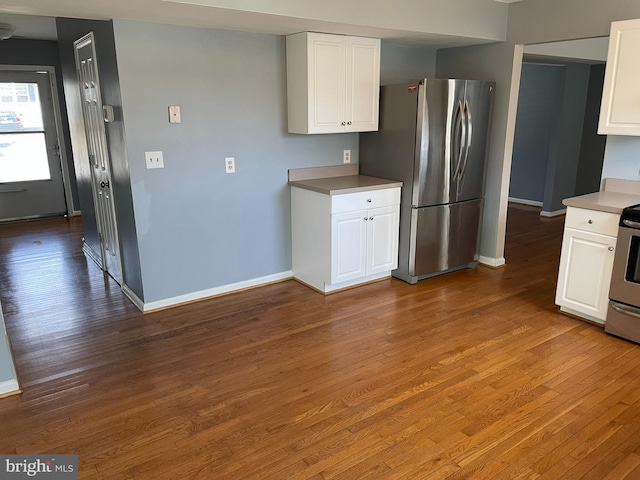 kitchen with white cabinets, appliances with stainless steel finishes, and hardwood / wood-style floors