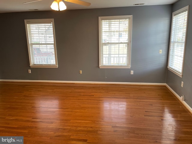 unfurnished room featuring hardwood / wood-style flooring and a wealth of natural light